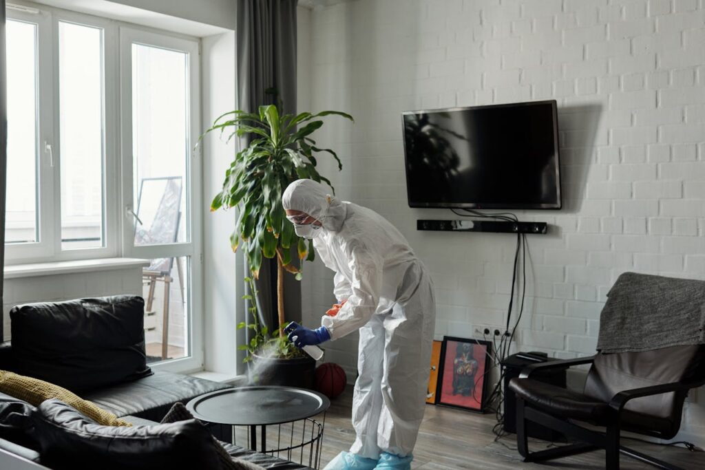 pexels photo 4098778 Worker in PPE disinfecting a living room, ensuring safety from viruses.